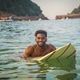 Young black man swimming with surfboard enjoying summer vacation Young black man swimming with surfboard enjoying summer vacation - PhotoDune Item for Sale