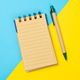Minimalist Notepad and Pen on blue and yellow Background Minimalist Notepad and Pen on blue and yellow Background - PhotoDune Item for Sale