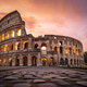 The Colosseum illuminated under a fiery sunset sky with ancient basalt pavement. The Colosseum illuminated under a fiery sunset sky with ancient basalt pavement. - PhotoDune Item for Sale