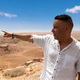Man in profile pointing at the panoramic view of the oasis in Tinghir. Man in profile pointing at the panoramic view of the oasis in Tinghir. - PhotoDune Item for Sale