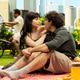 Young couple sitting closely together with intimate gaze on picnic blanket Young couple sitting closely together with intimate gaze on picnic blanket - PhotoDune Item for Sale