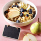 Oatmeal breakfast bowl with apple, pear and blueberries on pink background with blank blackboard Oatmeal breakfast bowl with apple, pear and blueberries on pink background with blank blackboard - PhotoDune Item for Sale