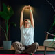 Middle aged woman on floor mat and doing stretching yoga position in modern Scandi dark interior hom Middle aged woman on floor mat and doing stretching yoga position in modern Scandi dark interior hom - PhotoDune Item for Sale