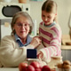 Senior Woman Receiving Care from Girl at Home for Family Support Senior Woman Receiving Care from Girl at Home for Family Support - PhotoDune Item for Sale