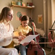 Woman Coaching School Age Girl in Cello Training for Music Education Woman Coaching School Age Girl in Cello Training for Music Education - PhotoDune Item for Sale