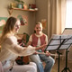 Woman Teaching Girl Music Lesson and Playing Instruments at Home Woman Teaching Girl Music Lesson and Playing Instruments at Home - PhotoDune Item for Sale