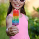 Child holding rainbow popsicle outdoors on sunny summer day, colorful frozen dessert close-up Child holding rainbow popsicle outdoors on sunny summer day, colorful frozen dessert close-up - PhotoDune Item for Sale