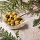Green Olives in a Glass Dish With Silver Spoon on a Stone Background Green Olives in a Glass Dish With Silver Spoon on a Stone Background - PhotoDune Item for Sale