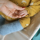 Baby hand holding adult hand in cozy nursery setting Baby hand holding adult hand in cozy nursery setting - PhotoDune Item for Sale