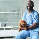 Portrait of Black Male Veterinarian Holding Dog in Clinic Portrait of Black Male Veterinarian Holding Dog in Clinic - PhotoDune Item for Sale