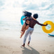 Friends, diverse couple having fun with colorful inflatable rings at the seaside Friends, diverse couple having fun with colorful inflatable rings at the seaside - PhotoDune Item for Sale