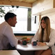 Couple drinking coffee and talking in camper van Couple drinking coffee and talking in camper van - PhotoDune Item for Sale