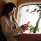 Woman relaxing inside camper van using smartphone Woman relaxing inside camper van using smartphone - PhotoDune Item for Sale