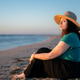 Woman with vitiligo sitting on beach at sunset Woman with vitiligo sitting on beach at sunset - PhotoDune Item for Sale