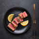 Seared grilled tuna steak tataki slices sesame seeds lemon black plate healthy delicacy Seared grilled tuna steak tataki slices sesame seeds lemon black plate healthy delicacy - PhotoDune Item for Sale