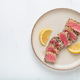 Seared grilled tuna steak tataki slices sesame seeds lemon white plate delicacy asian Japanese copy Seared grilled tuna steak tataki slices sesame seeds lemon white plate delicacy asian Japanese copy - PhotoDune Item for Sale