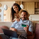 Happy couple of travelers paying online with credit card and laptop. Happy couple of travelers paying online with credit card and laptop. - PhotoDune Item for Sale