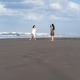 Young Woman Photographing Friend on Wide Sandy Beach in Yogyakarta Young Woman Photographing Friend on Wide Sandy Beach in Yogyakarta - PhotoDune Item for Sale