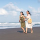 Happy Indonesian Friends Walking on Beach Under Blue Sky Happy Indonesian Friends Walking on Beach Under Blue Sky - PhotoDune Item for Sale