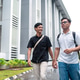 Two Asian Indonesian Men Walking and Talking on Campus Path Two Asian Indonesian Men Walking and Talking on Campus Path - PhotoDune Item for Sale