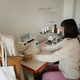 Dressmaker working at a sewing machine in a small studio with mannequin and fabrics Dressmaker working at a sewing machine in a small studio with mannequin and fabrics - PhotoDune Item for Sale