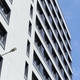 Bright contemporary tower facade stretches upward beside blue sky Bright contemporary tower facade stretches upward beside blue sky - PhotoDune Item for Sale