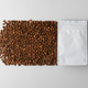 White coffee pouch creates flowing trail of roasted beans on gray background for branding White coffee pouch creates flowing trail of roasted beans on gray background for branding - PhotoDune Item for Sale