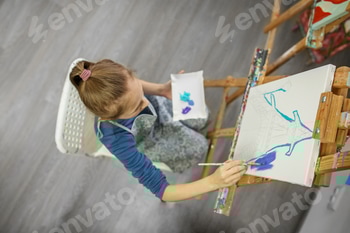 Concentrated Child Painting on Easel. Top view. 2 E101IVKS.jpg?w=350&h=350&cf fit=scale down&mark=https%3A%2F%2Fassets.market storefront.envato static.com%2Fwatermarks%2Fphoto 260724