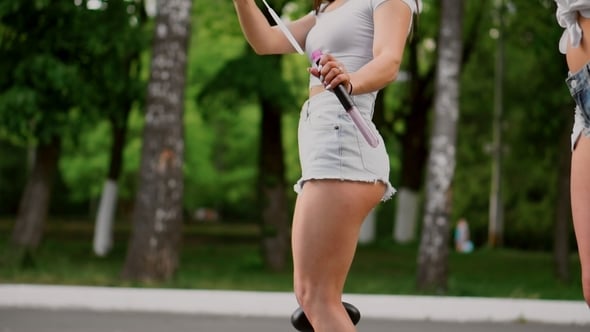 Two Beautiful Young Girls in Sexy Clothes Are Laughing and Dancing While Riding a Segway in the Park, Stock Footage Two Beautiful Young Girls in Sexy Clothes Are Laughing and Dancing While Riding a Segway in the Park, Stock Footage